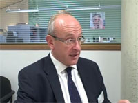 A man in a dark suit and glasses